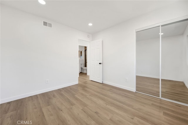 unfurnished bedroom with a closet and light hardwood / wood-style floors