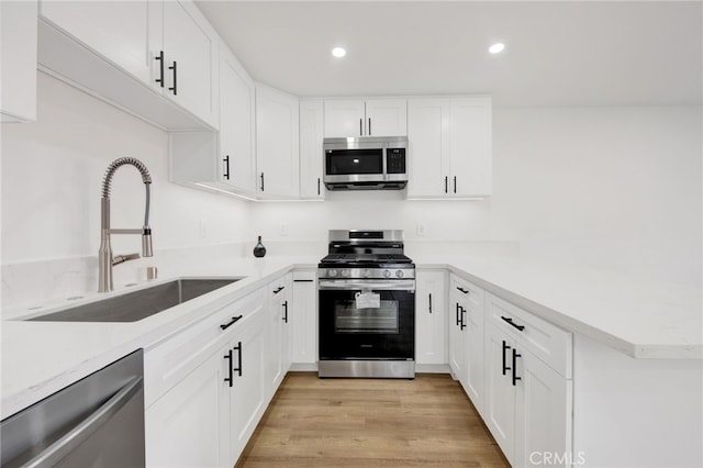 kitchen with sink, stainless steel appliances, and white cabinetry