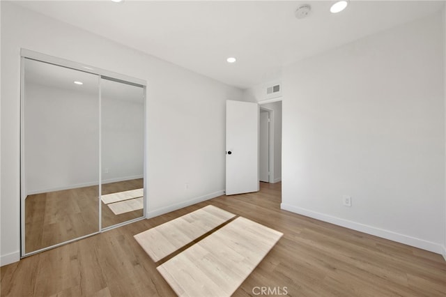 unfurnished bedroom featuring a closet and light hardwood / wood-style floors