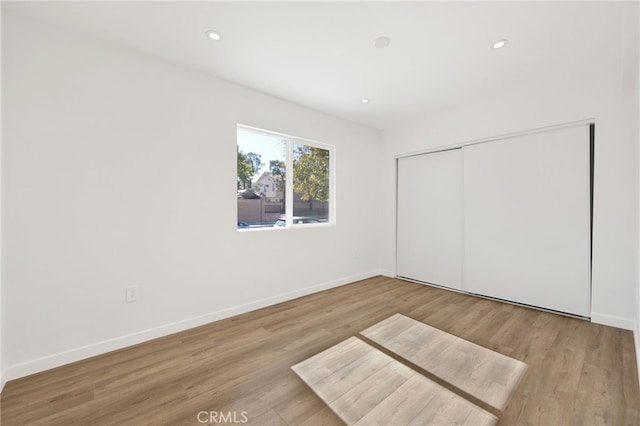 unfurnished bedroom featuring light hardwood / wood-style floors and a closet