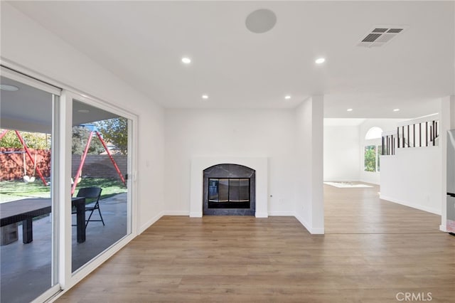 unfurnished living room featuring a healthy amount of sunlight and light hardwood / wood-style flooring