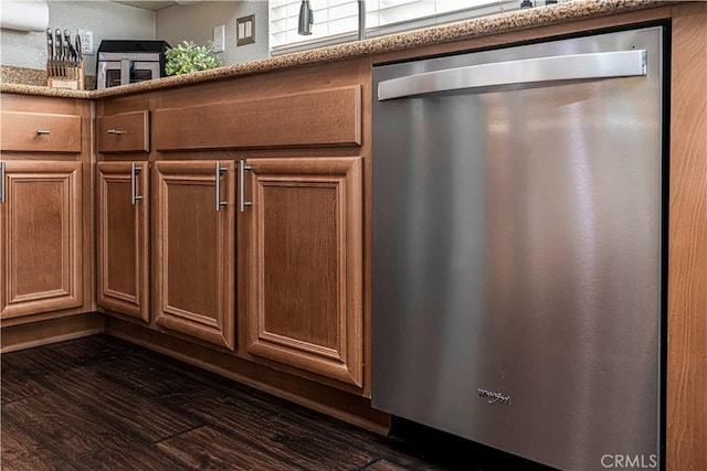 room details with dark wood-type flooring and stainless steel dishwasher