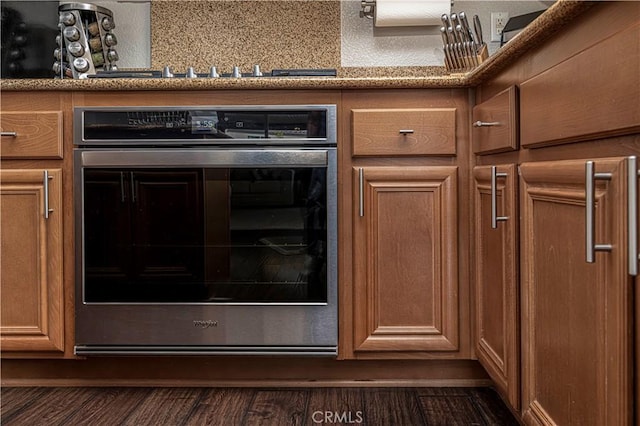 interior details with dark wood-type flooring, stainless steel oven, and black stovetop