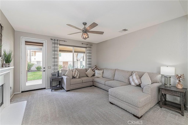 carpeted living room featuring ceiling fan