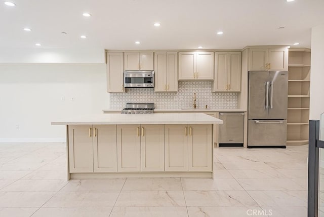 kitchen with sink, appliances with stainless steel finishes, cream cabinetry, and a kitchen island