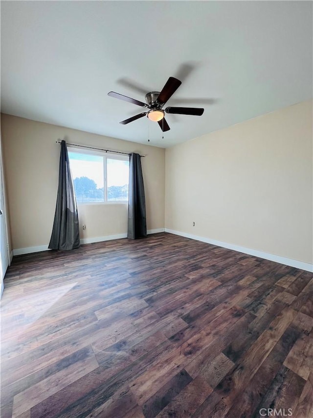 spare room with dark wood-type flooring and ceiling fan