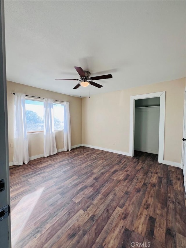 unfurnished bedroom with dark hardwood / wood-style floors, ceiling fan, and a closet