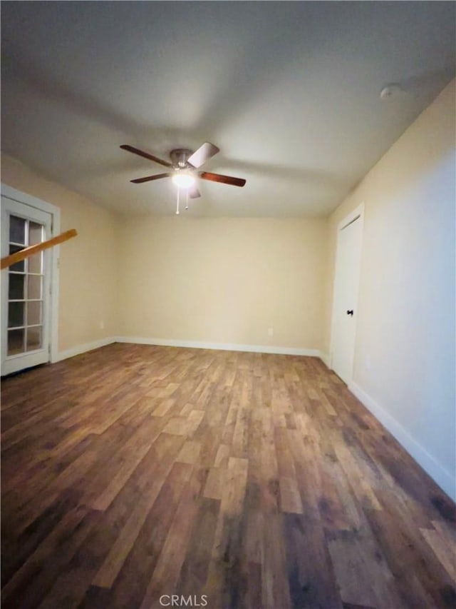 empty room with ceiling fan and dark hardwood / wood-style flooring