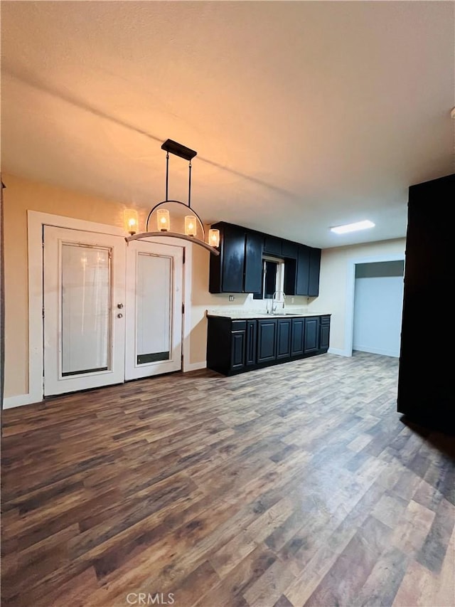 kitchen with dark wood-type flooring, decorative light fixtures, and sink