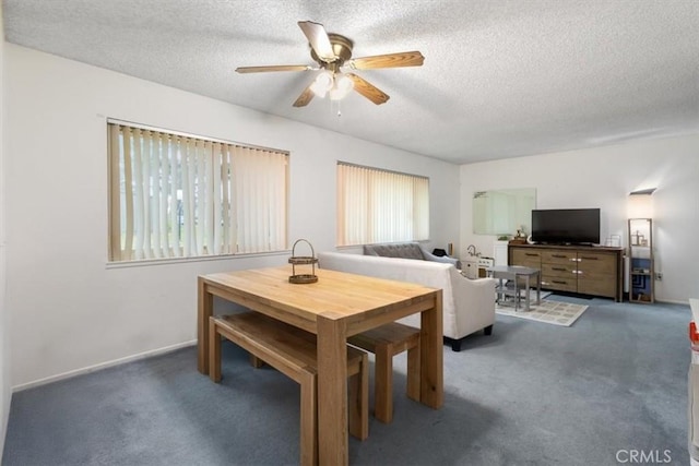 dining area featuring ceiling fan, a textured ceiling, and dark carpet