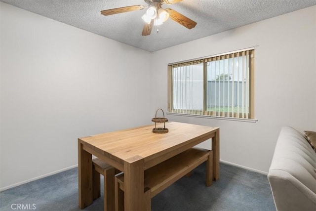 dining space with ceiling fan, a textured ceiling, and dark carpet