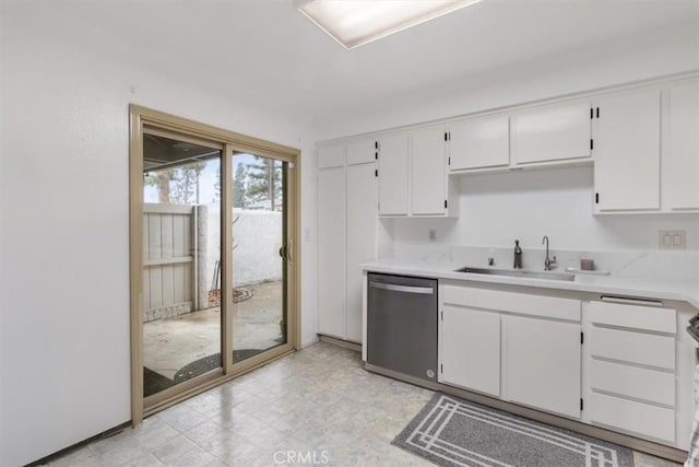 kitchen featuring stove, sink, stainless steel dishwasher, and white cabinets