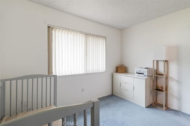 bedroom with light carpet and a textured ceiling