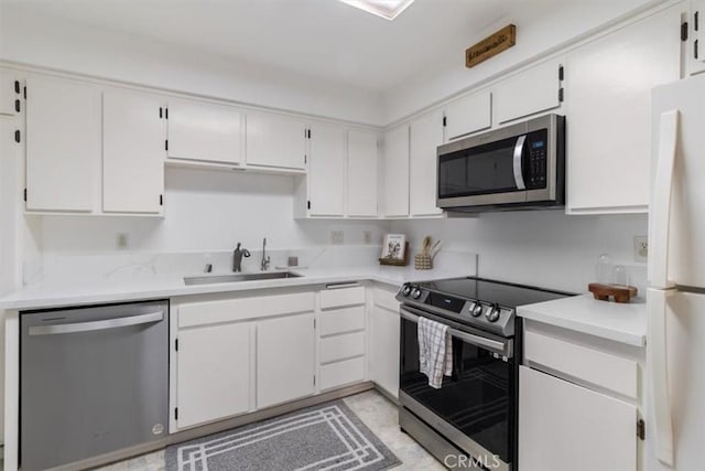 kitchen featuring appliances with stainless steel finishes, sink, and white cabinets