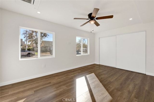 unfurnished bedroom with ceiling fan, dark hardwood / wood-style floors, and a closet