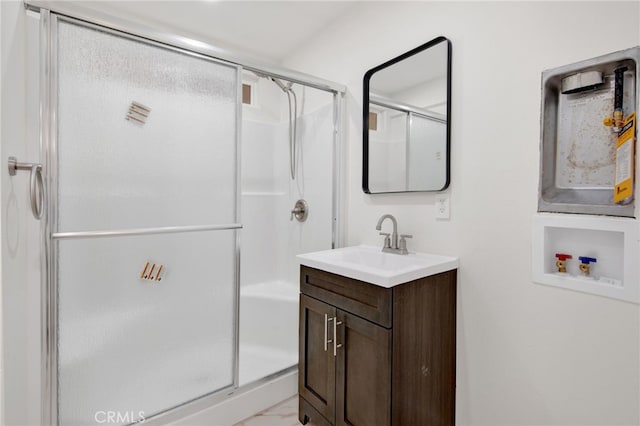 bathroom featuring vanity and a shower with door