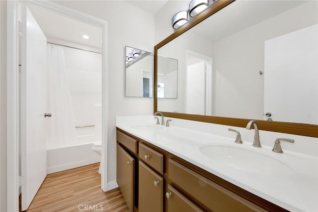 full bathroom with toilet, shower / bath combination with curtain, hardwood / wood-style flooring, and vanity