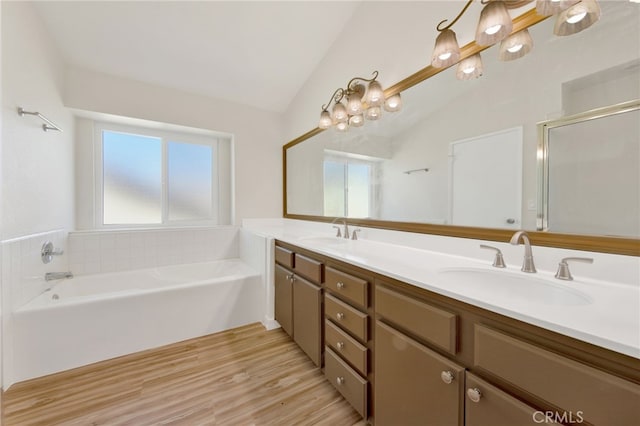 bathroom featuring vaulted ceiling, plenty of natural light, and vanity