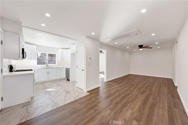 unfurnished living room featuring ceiling fan, light hardwood / wood-style flooring, and sink