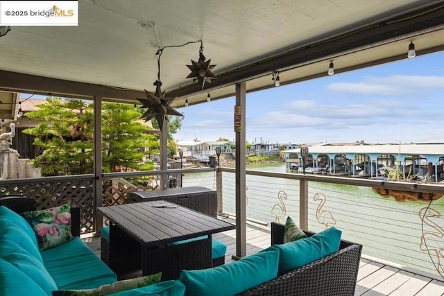 view of dock with outdoor lounge area and a deck with water view