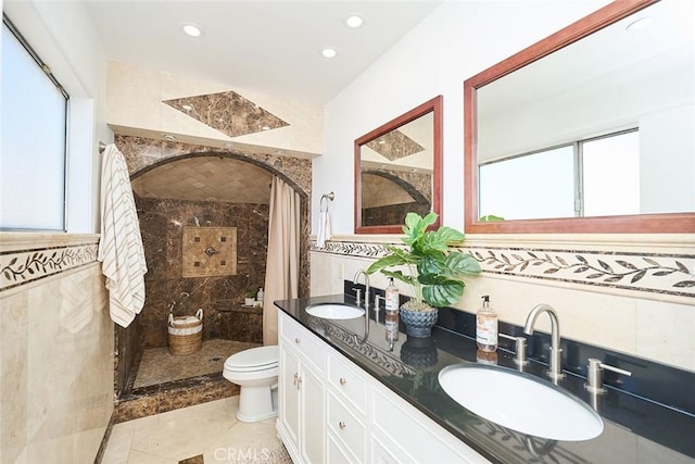 bathroom featuring toilet, tile walls, vanity, and a shower with shower curtain