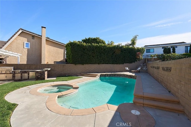 view of swimming pool with an in ground hot tub, a patio area, and exterior kitchen