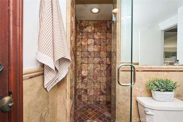 bathroom featuring tile walls, toilet, and walk in shower