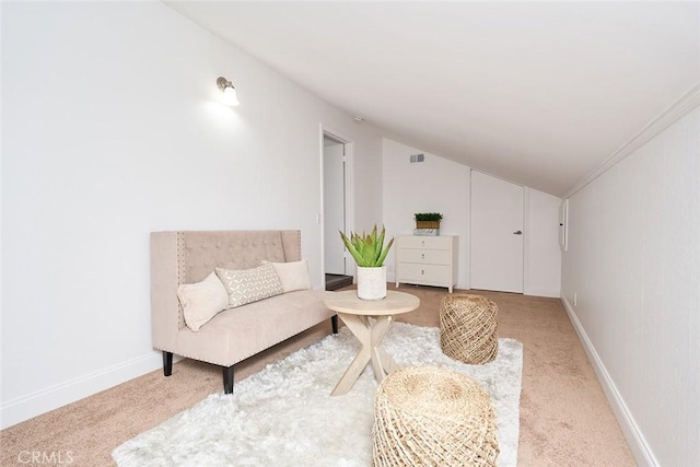 sitting room with vaulted ceiling, carpet flooring, and ornamental molding