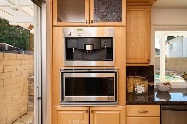 kitchen with dark stone counters and appliances with stainless steel finishes