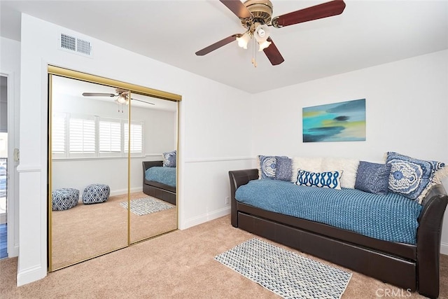 carpeted bedroom featuring a closet and ceiling fan