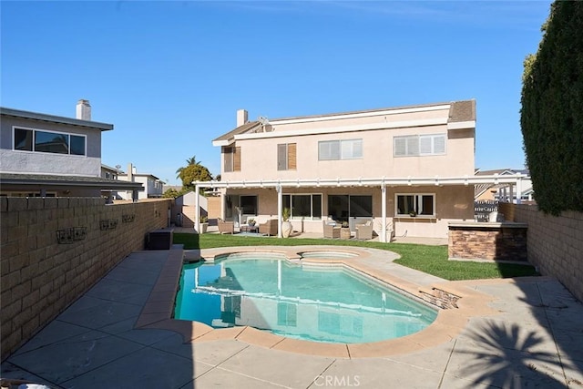 back of property with a pool with hot tub and a patio area