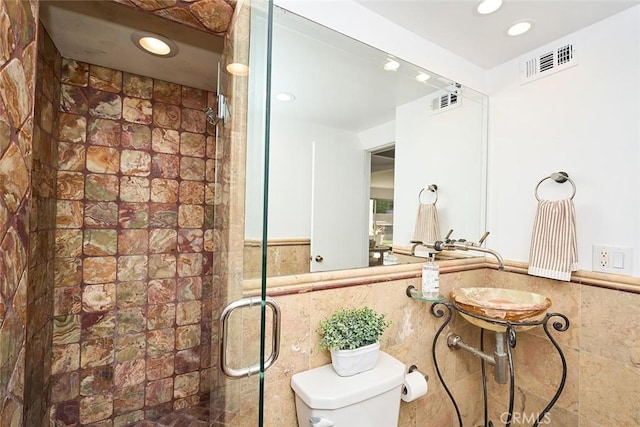 bathroom with sink, tile walls, toilet, and walk in shower