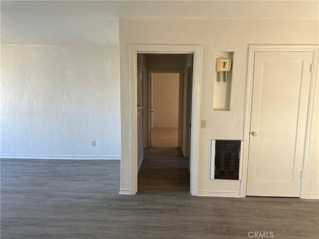 hall with dark hardwood / wood-style flooring and heating unit