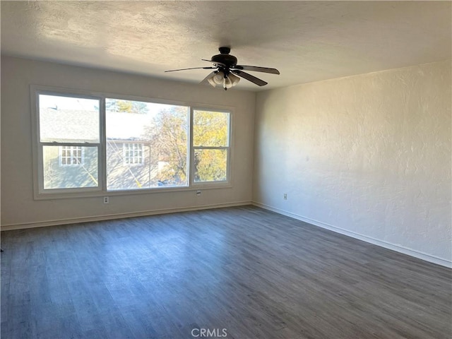 spare room featuring ceiling fan, dark hardwood / wood-style flooring, and a textured ceiling