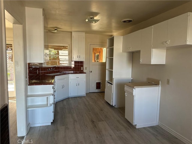 kitchen featuring dark wood-type flooring, white cabinets, and tasteful backsplash