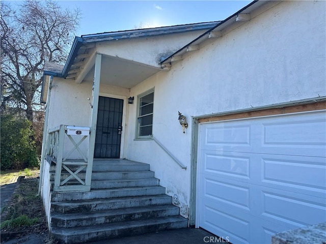 doorway to property with a garage