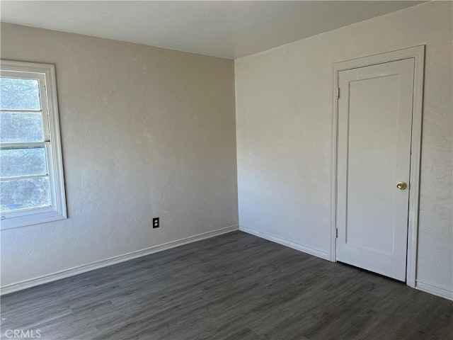 empty room with dark hardwood / wood-style flooring