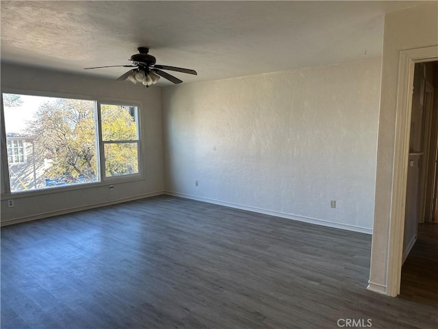 spare room with ceiling fan and dark hardwood / wood-style floors