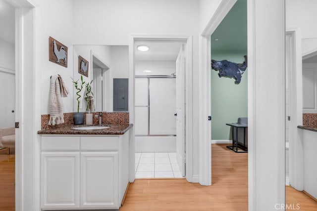 interior space featuring vanity, an enclosed shower, and hardwood / wood-style floors