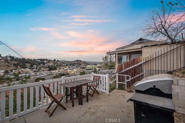 balcony at dusk with grilling area and a patio area