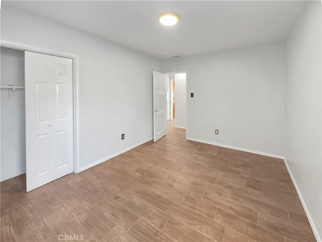 unfurnished bedroom featuring wood-type flooring and a closet