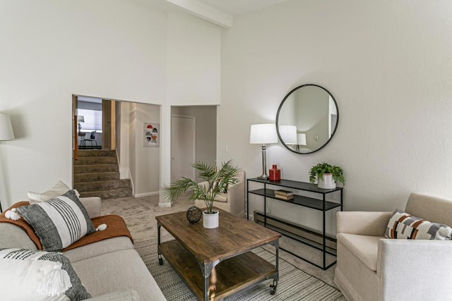 carpeted living room featuring a baseboard heating unit and a towering ceiling