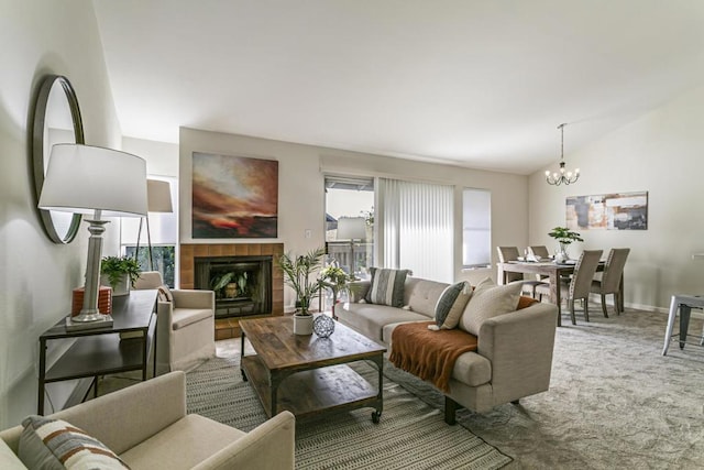 carpeted living room featuring a wealth of natural light, lofted ceiling, a tiled fireplace, and an inviting chandelier