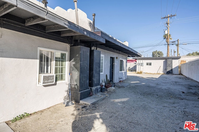 view of property exterior with cooling unit and an outdoor structure