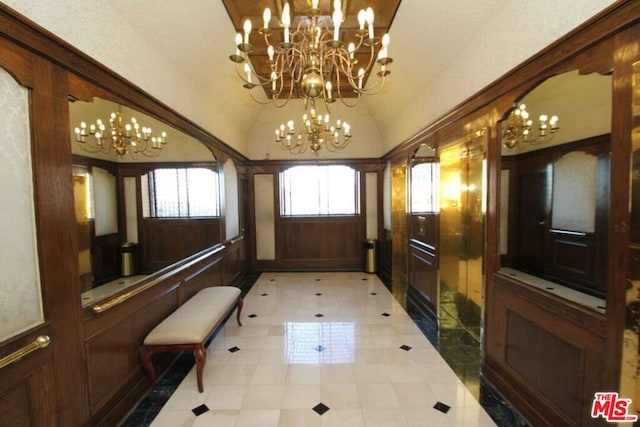 tiled entryway featuring an inviting chandelier and high vaulted ceiling