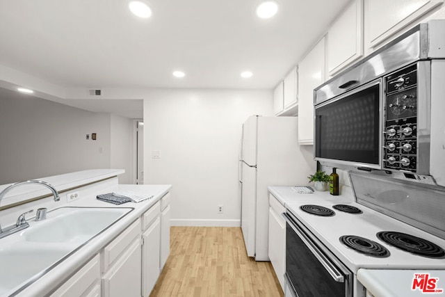 kitchen with light hardwood / wood-style floors, electric stove, white cabinetry, and sink