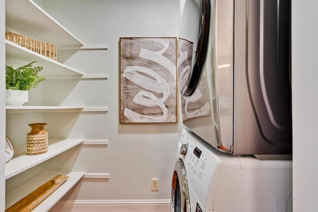 clothes washing area featuring stacked washer and clothes dryer