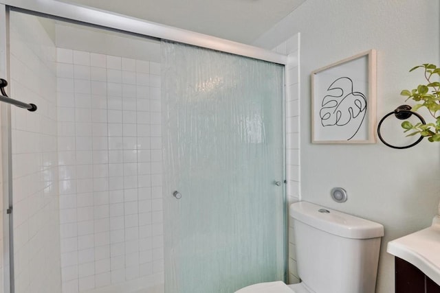 bathroom featuring vanity, an enclosed shower, and toilet