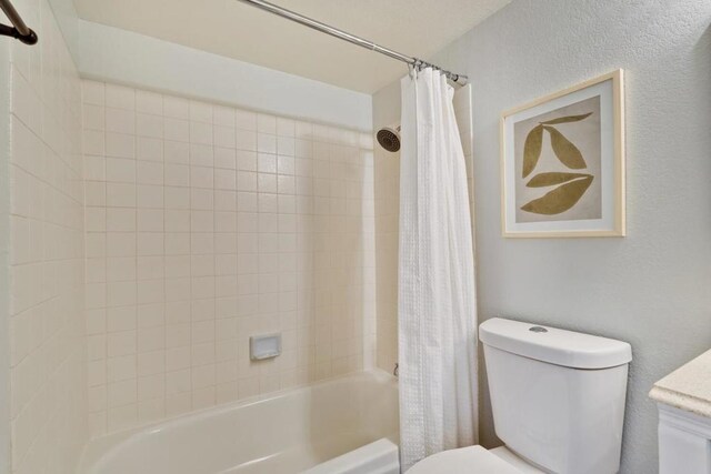 full bathroom with shower / tub combo with curtain, vanity, and toilet