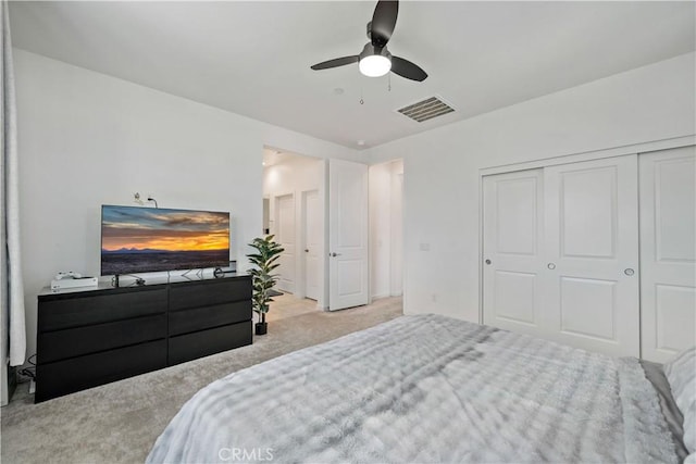 bedroom featuring light colored carpet, a closet, and ceiling fan